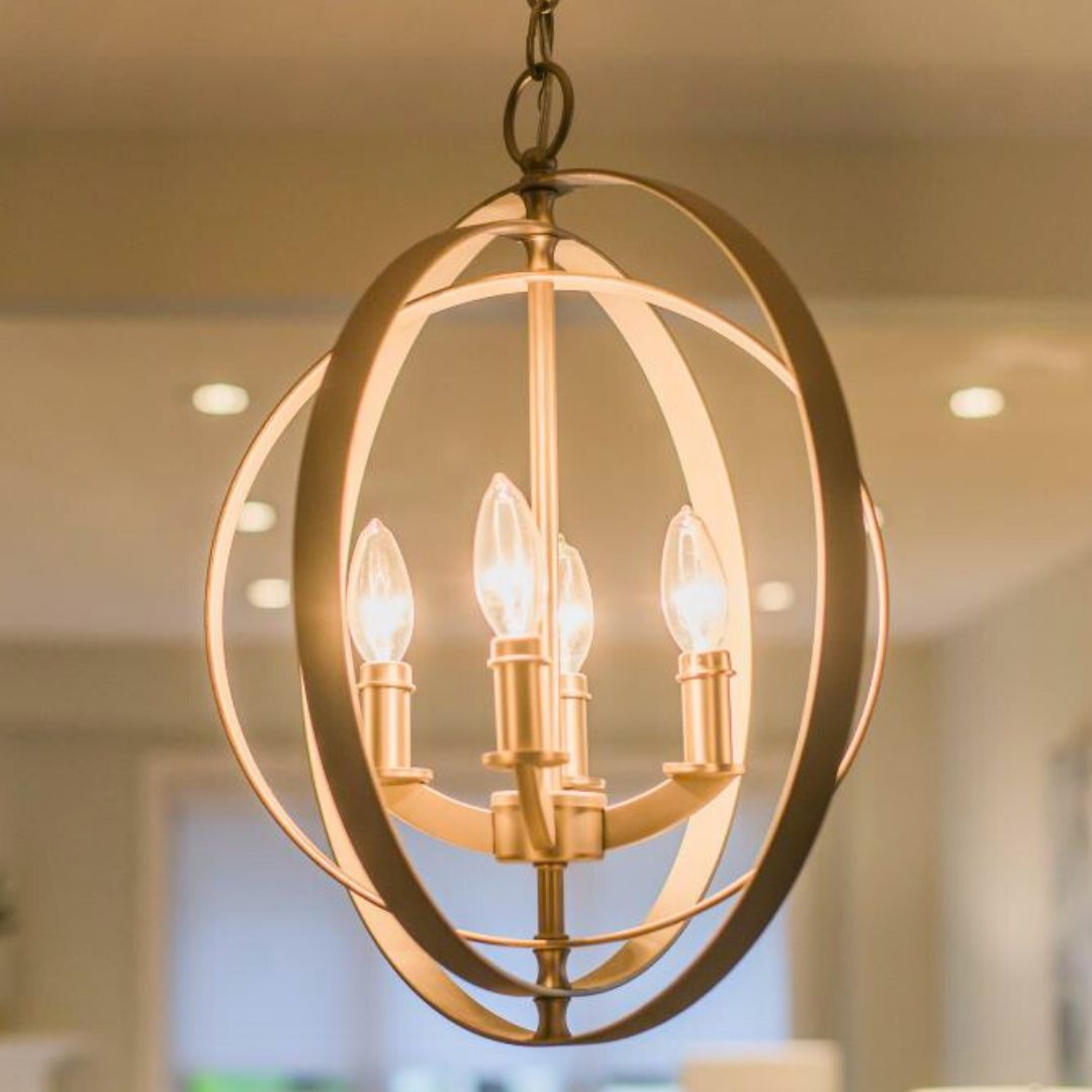 Elegant gold orb chandelier with four candle-style lights, hanging in a bathroom. Adds a touch of luxury to the space.
