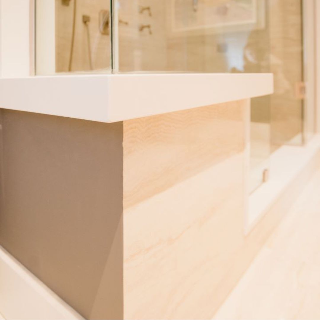 Close-up of a sleek modern floating bathroom vanity with a crisp white countertop and warm wood-grain drawers, showcasing clean lines and minimalist design. 