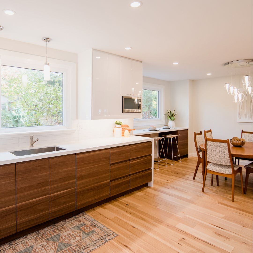Contemporary kitchen and dining area featuring walnut cabinetry, light wood flooring, and a cozy breakfast nook.
