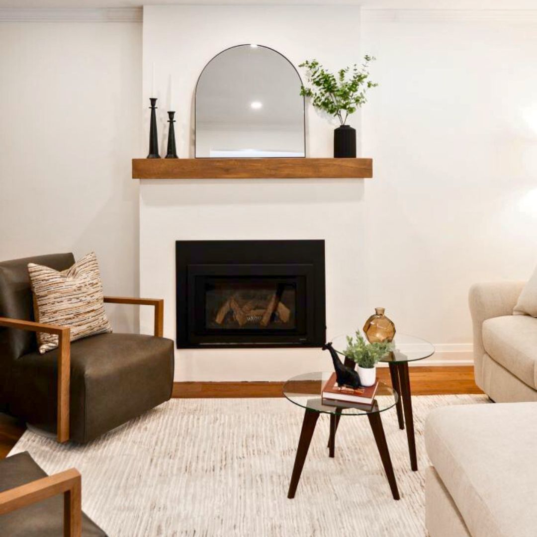 Contemporary living room design featuring a minimalist fireplace with a wood mantel, modern decor elements, and neutral furnishings.