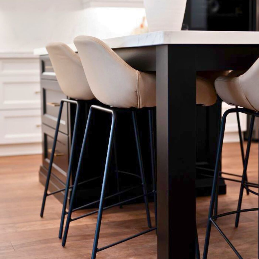 Modern kitchen island seating featuring black wood legs and beige upholstered bar stools. A sleek and contemporary design with comfortable seating