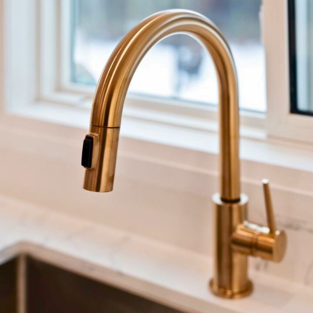 Brushed gold kitchen faucet featuring a sleek curved design and modern lever handle.